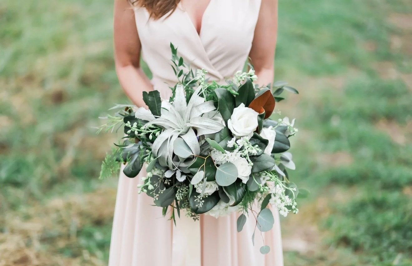 Bride holding a soft white and green bouquet