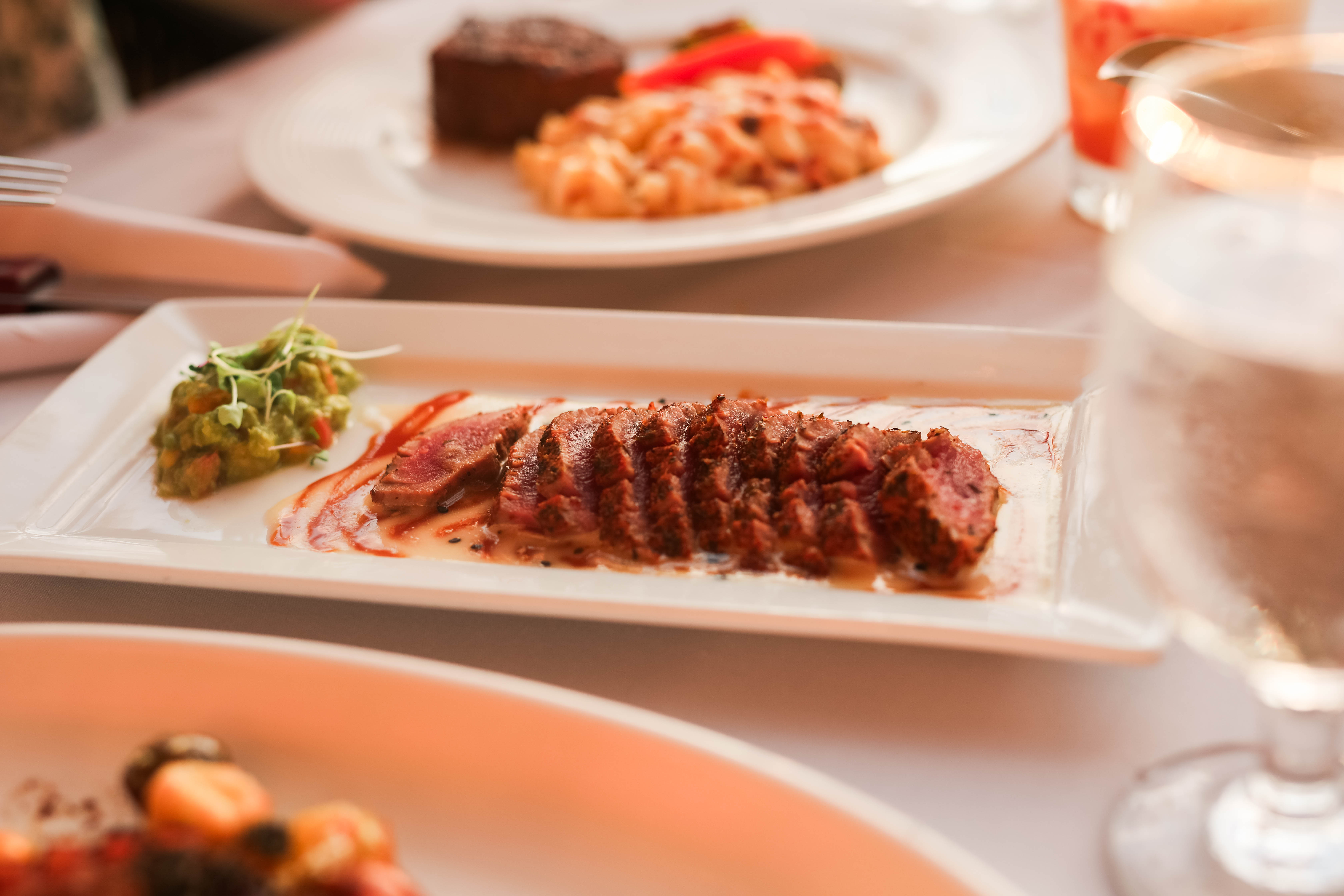 Sliced grilled steak served on a white platter